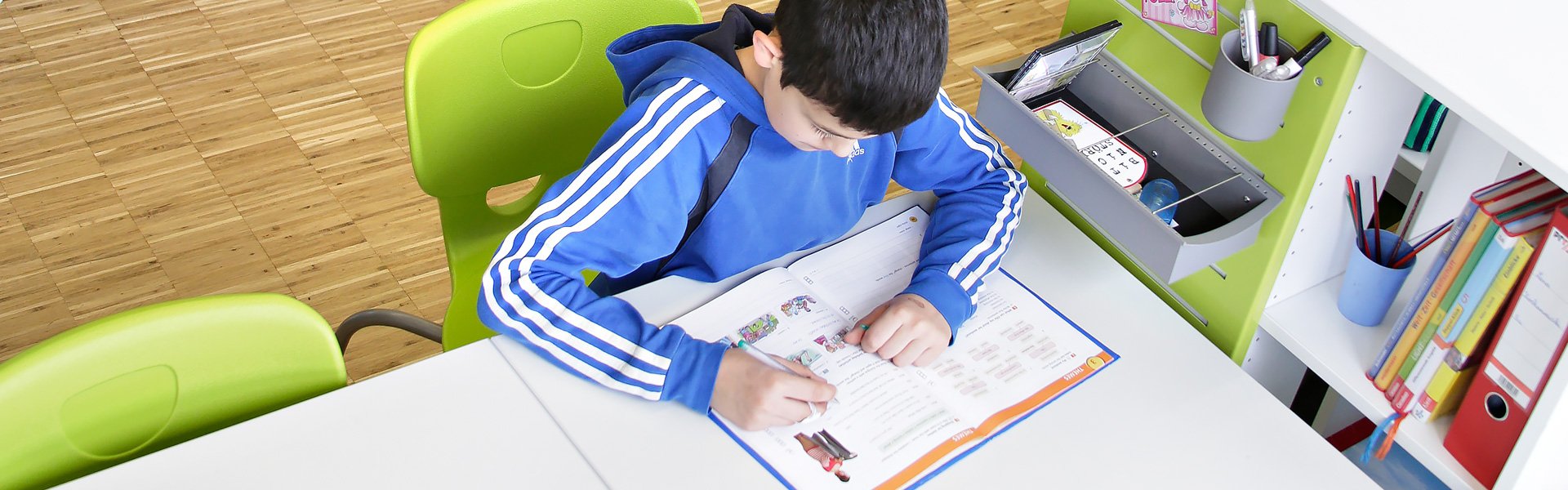 Image: boy is sitting and reading in a learning room